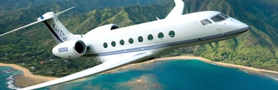 a sleek business jet flying over a coastal landscape, likely indicating the aircraft's capability for private, luxury travel. The design features multiple windows, a pointed nose, and winglets at the tips of its wings, characteristic of modern business jets designed for speed and efficiency. The setting is picturesque and serene, possibly implying the exclusive and leisurely experience of flying on a private jet. The registration number is visible on the tail, which is a requirement for aircraft identification.