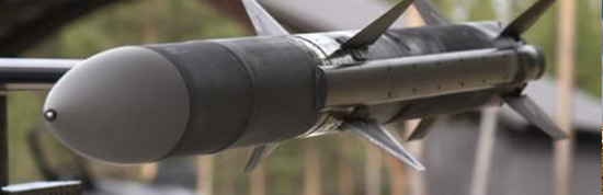 a close-up view of a missile. The missile has a pointed nose, cylindrical body, and fins or stabilizers, which are typical characteristics of such an object designed to be propelled through the air. It is likely mounted on a stand or part of a display, suggesting that it may not be in operational condition, but rather exhibited for demonstration, educational, or decommissioned display purposes.