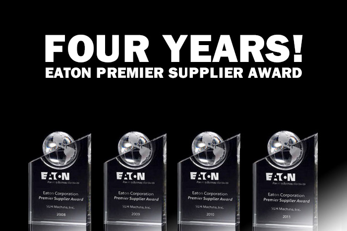 The image features a bold title that says FOUR YEARS! which likely indicates a celebration or acknowledgment of a consistent achievement across four years. Below this title are four clear acrylic trophies with black bases lined up in a row. Each trophy is engraved with the logo and name of Eaton Corporation, a power management company, and includes the text Premier Supplier Award. The trophies are for consecutive years, starting from 2008 to 2011, awarded to S&H Machine, Inc. This suggests that S&H Machine, Inc. has been recognized as a premier supplier by Eaton Corporation for four consecutive years, highlighting the company's consistent performance and reliability as a supplier.